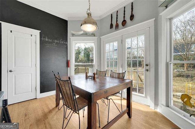 dining room featuring ornamental molding and light hardwood / wood-style floors