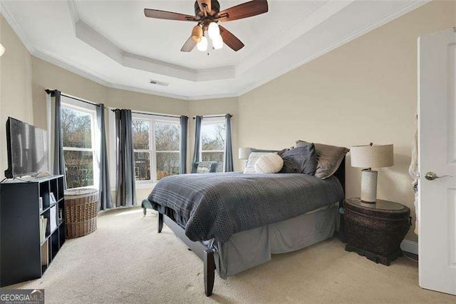 carpeted bedroom featuring crown molding, ceiling fan, and a tray ceiling