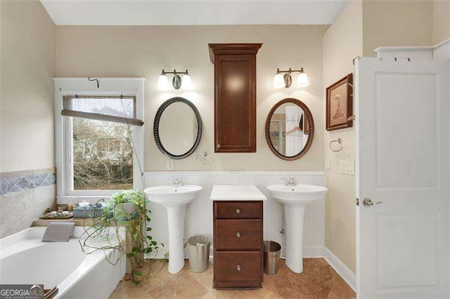 bathroom with double sink and a bath