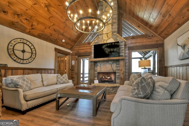 living room featuring an inviting chandelier, hardwood / wood-style floors, a fireplace, and wooden ceiling