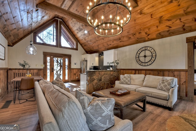 living room with an inviting chandelier, wood ceiling, high vaulted ceiling, wooden walls, and hardwood / wood-style floors