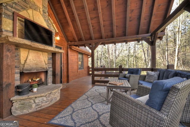 wooden terrace featuring an outdoor living space with a fireplace