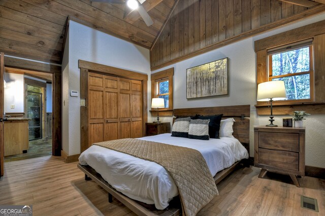 bedroom with a closet, high vaulted ceiling, light hardwood / wood-style flooring, and wooden ceiling