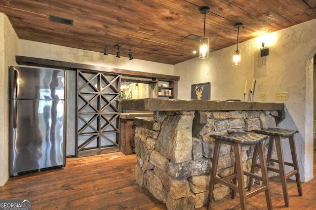 bar featuring pendant lighting, stainless steel refrigerator, wood ceiling, dark wood-type flooring, and track lighting