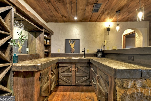 bar with dark hardwood / wood-style flooring, wood ceiling, and pendant lighting