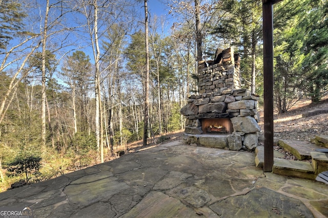 view of patio featuring an outdoor stone fireplace