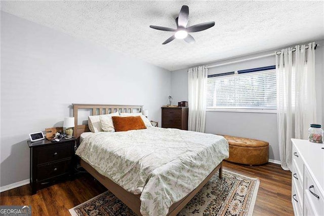 bedroom featuring dark hardwood / wood-style flooring, ceiling fan, and a textured ceiling