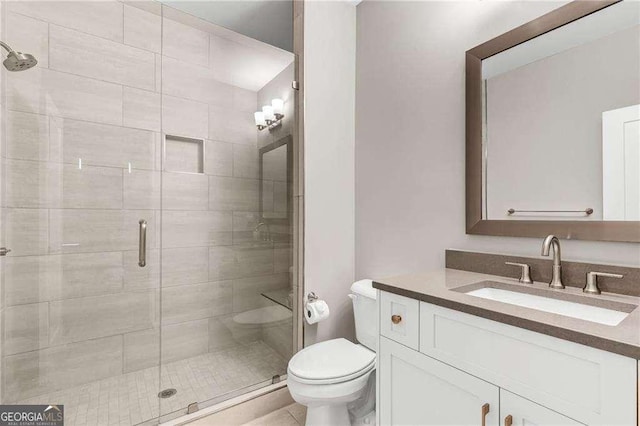 bathroom featuring vanity, an enclosed shower, and toilet