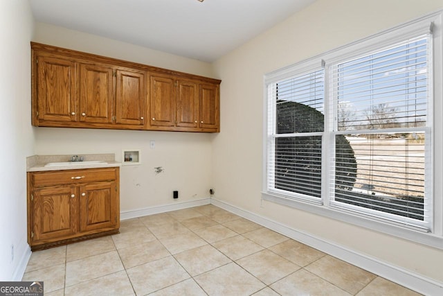 laundry area featuring sink, cabinets, light tile patterned floors, electric dryer hookup, and washer hookup