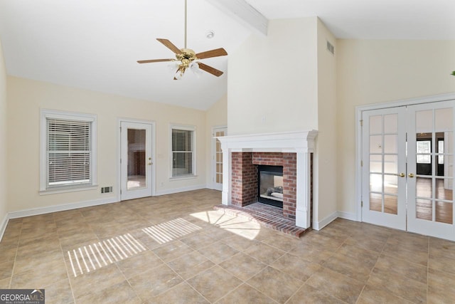 unfurnished living room with ceiling fan, high vaulted ceiling, a fireplace, french doors, and beamed ceiling