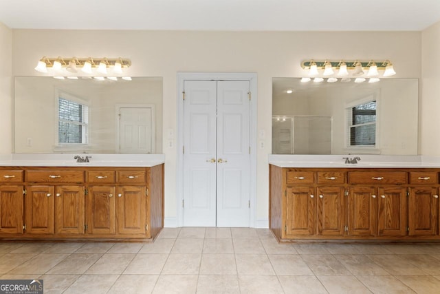 bathroom featuring a shower with door, vanity, and tile patterned flooring