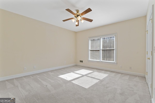 spare room featuring ceiling fan and light carpet