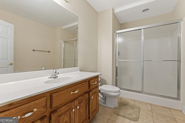 bathroom featuring vanity, a shower with shower door, tile patterned floors, and toilet