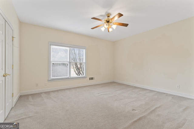 carpeted spare room with ceiling fan