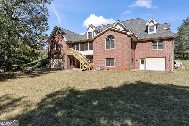 back of property featuring a garage, a sunroom, and a lawn