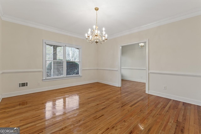 unfurnished room featuring crown molding, wood-type flooring, and a notable chandelier