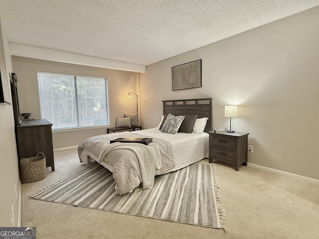 bedroom featuring light carpet and a textured ceiling