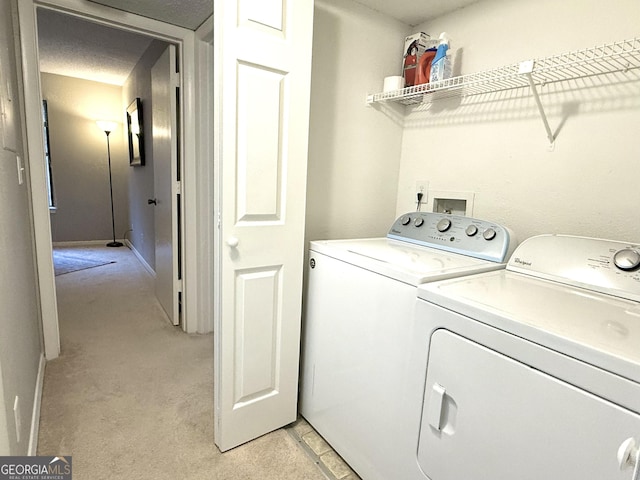 laundry room featuring washer and clothes dryer and light colored carpet