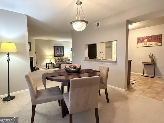 dining area featuring sink and light carpet