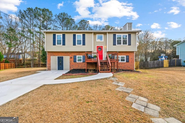 split foyer home with a wooden deck and a front lawn