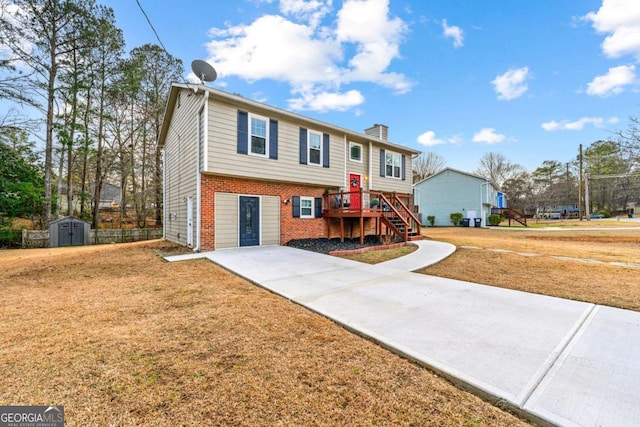 raised ranch with a front lawn and a storage unit