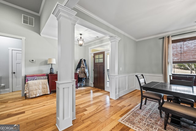 dining area featuring ornate columns, ornamental molding, and light hardwood / wood-style floors