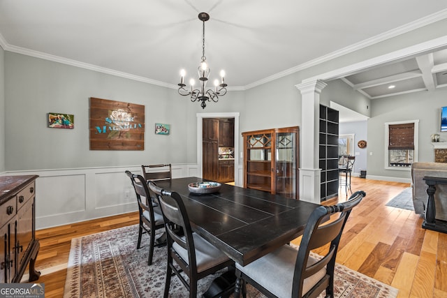 dining room featuring crown molding, beamed ceiling, light hardwood / wood-style floors, and ornate columns