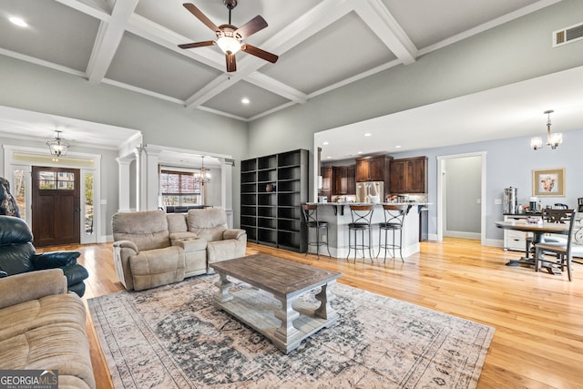 living room featuring coffered ceiling, decorative columns, beam ceiling, and light wood-type flooring