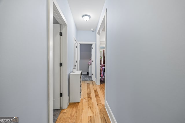 hallway with light hardwood / wood-style floors