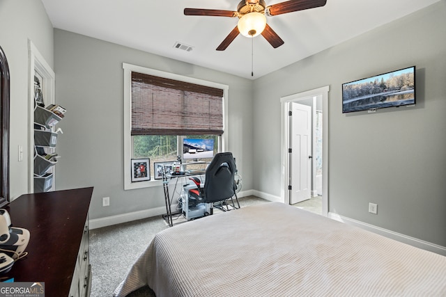 bedroom featuring ceiling fan, ensuite bath, and light carpet