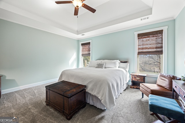 carpeted bedroom featuring ceiling fan, ornamental molding, and a tray ceiling