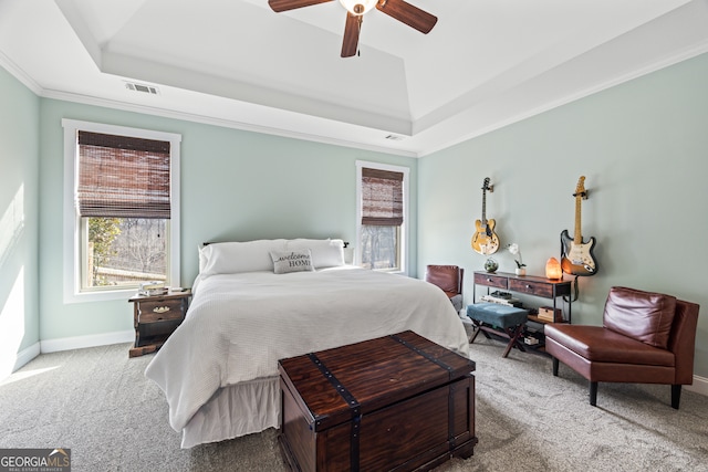 bedroom featuring ceiling fan, carpet flooring, ornamental molding, and a tray ceiling