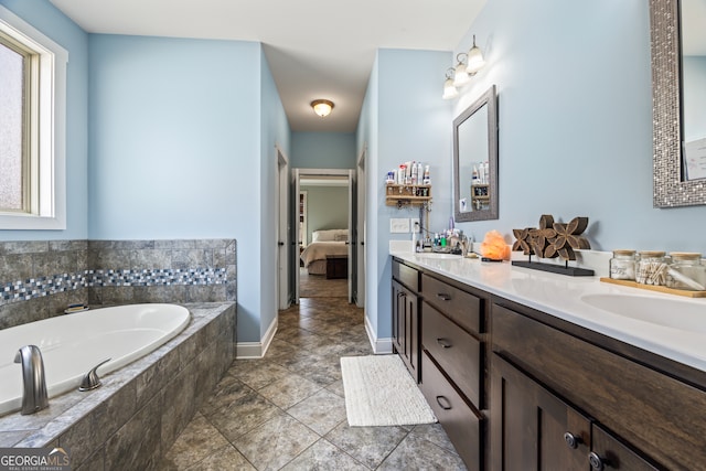 bathroom featuring vanity, tiled bath, and tile patterned flooring