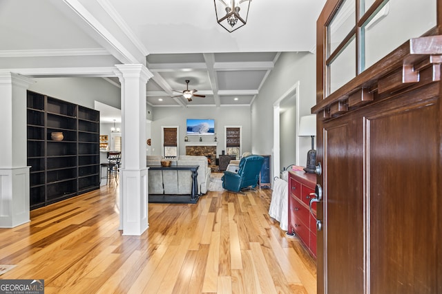 entrance foyer with ornate columns, ceiling fan with notable chandelier, beamed ceiling, coffered ceiling, and light hardwood / wood-style floors