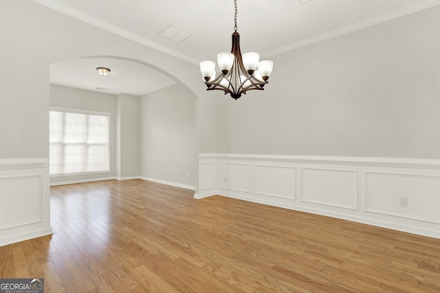 unfurnished room with ornamental molding, light hardwood / wood-style floors, and a notable chandelier