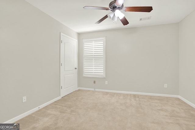 carpeted spare room with ceiling fan