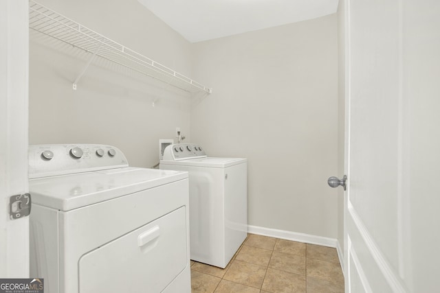 clothes washing area with washing machine and clothes dryer and light tile patterned floors