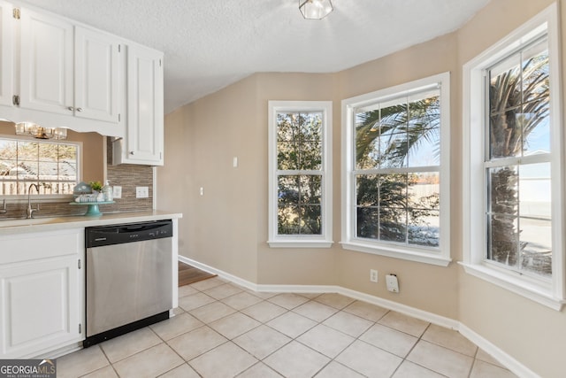 kitchen with white cabinetry, stainless steel dishwasher, sink, and a wealth of natural light