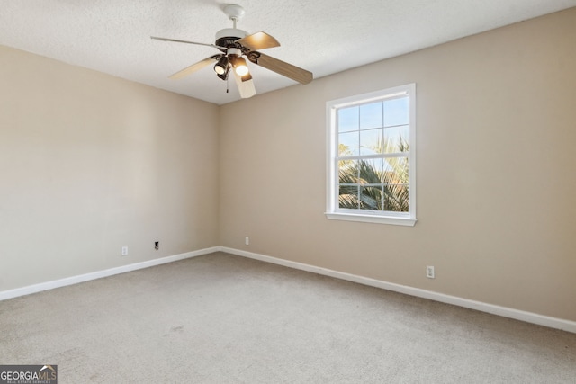 carpeted empty room with ceiling fan and a textured ceiling