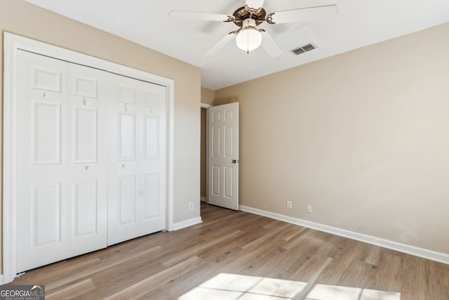 unfurnished bedroom featuring light hardwood / wood-style floors, a closet, and ceiling fan