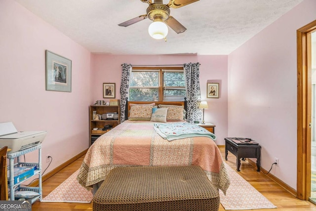 bedroom featuring ceiling fan, a textured ceiling, and light wood-type flooring