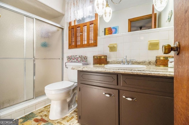 bathroom featuring tile walls, vanity, an enclosed shower, decorative backsplash, and toilet