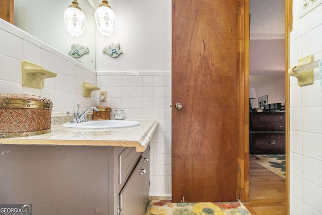 bathroom featuring tile walls, vanity, and hardwood / wood-style floors