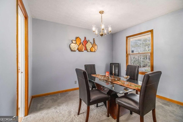 carpeted dining space featuring a chandelier and a textured ceiling