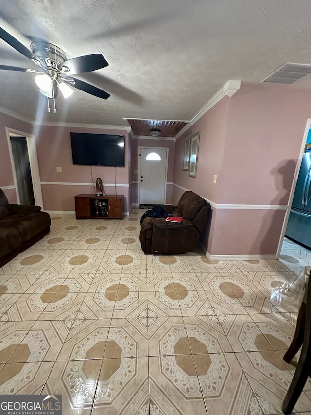 tiled living room featuring ornamental molding, ceiling fan, and a textured ceiling