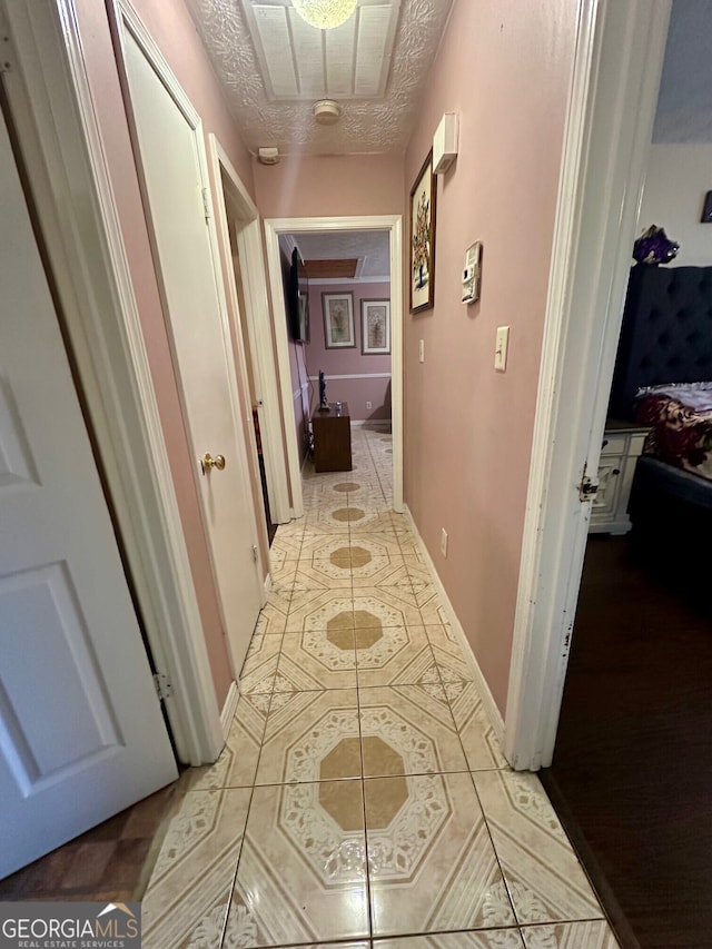 corridor featuring light tile patterned floors and a textured ceiling