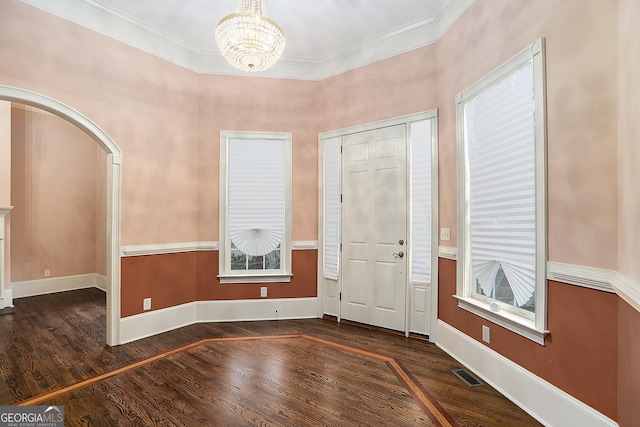 foyer entrance featuring crown molding, dark hardwood / wood-style floors, and a chandelier