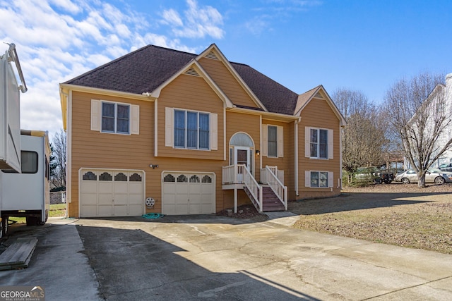 bi-level home featuring driveway, a shingled roof, and an attached garage