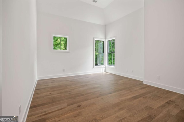 unfurnished room with dark hardwood / wood-style flooring