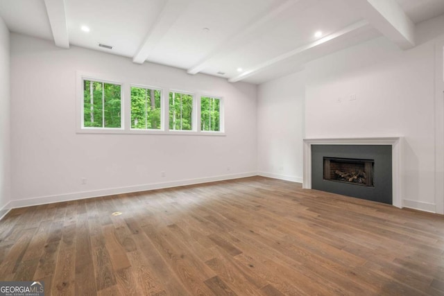 unfurnished living room featuring beam ceiling and wood-type flooring